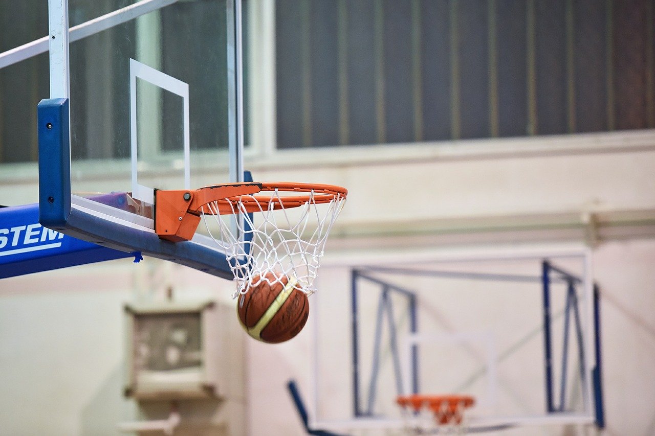 basket ball net with a ball going through the hoop